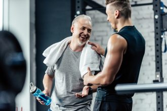 Personal trainer congratulating senior on achieving personal training goals.