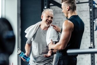 Personal trainer congratulating senior on achieving personal training goals.